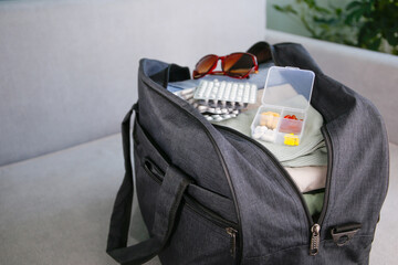 Clothes and pills in a travel bag. Concept of medication required in journey