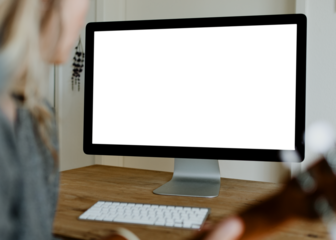 Woman using a computer screen mockup while playing ukulele during quarantine