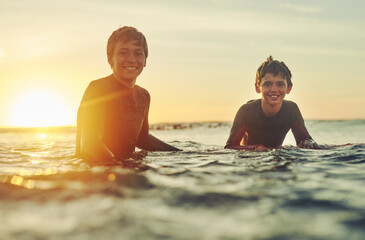 Beach, sunset and portrait of boys with surfboard for holiday, outdoor adventure and fun weekend...