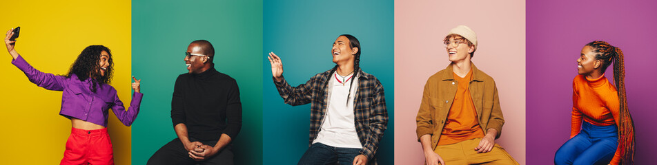 Group of young adults posing in colorful studio with vibrant backdrops