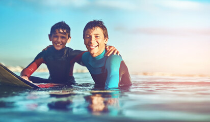 Kids, portrait and happy in water for surfing, sports and and wellness with board, blue sky and...