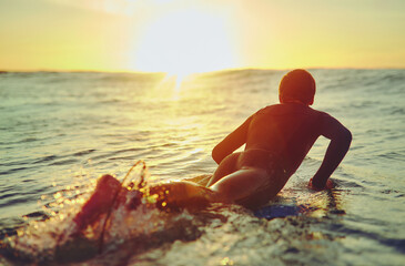 Beach, summer and person on wave with surfboard for holiday, outdoor adventure and weekend in...