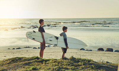Sunset, surf and kids on beach with board for adventure on vacation, holiday or sport in water....