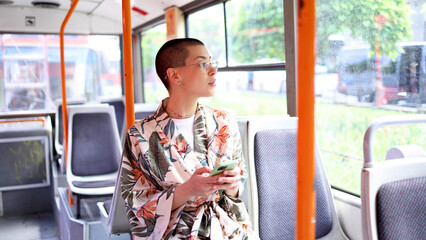 Beautiful short-haired girl riding in a bus and using smartphone