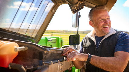 Close Up Of Mature Male Farm Worker Fixing Machinery