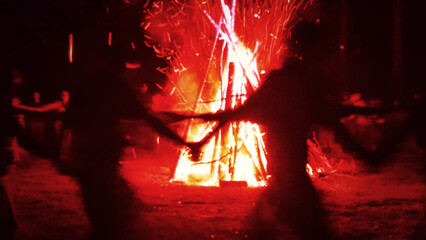 Huge fire at night and young people around. Pagan festival of Walpurgis night: bonfires, dancing...