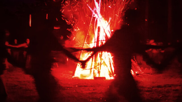 Huge fire at night and young people around. Pagan festival of Walpurgis night: bonfires, dancing wildly, witches. Figure of Witches Queen (HexenkР&ldquo;В&para;nigin). German legends, St. Walburgas and Satanism