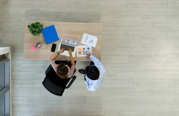 Two business people meeting around a small table with document paper, folder, mobile phone and...