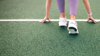 Close Up Of Female Athlete With Feet On Starting Line Before Start Of Race