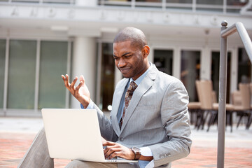 Frustrated businessman reading bad news on laptop computer 