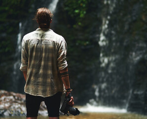 Back, man and waterfall with camera for photography in Thailand for portfolio, project or magazine. Travel, trip and explore with adventure as photographer or tourist on holiday or vacation at river