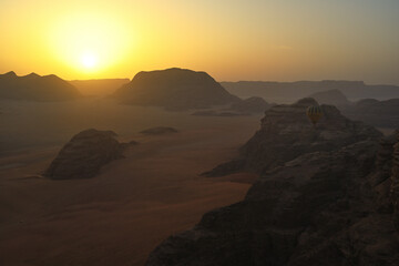 Eine Ballonfahrt bei Sonnenaufgang in der Wüste, mit panoramablick aus dem Ballon auf die endlose...