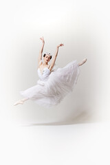Ballerina in white dress, frozen in mid-air as she performs ballet leap, her expression serene...