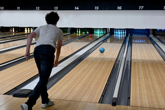 child from behind playing booling