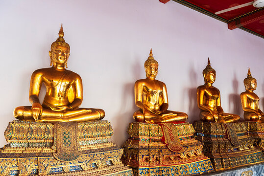Rows of golden Buddha statues in a temple of Wat Pho, Bangkok, Thailand