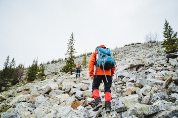 A group of hikers faces challenges on a rugged mountain trail, savoring the wildernesss beauty,...