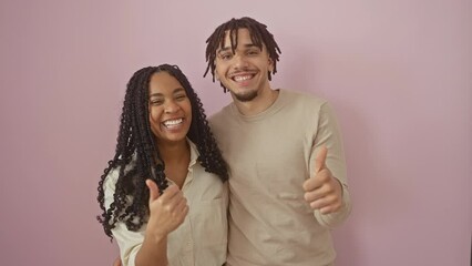 Beautiful couple exhibiting happy signals, upstanding sign of positive approval and excellent joy over isolated pink background