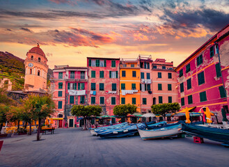 Old colorful buildings on the bank of Vernazza port with Santa Margherita di Antiochia Church....