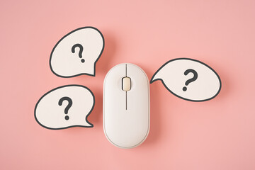 For online communication, customer service, internet search concept. Top view of wireless computer and  real white speech bubble paper cut with question marks on pink background