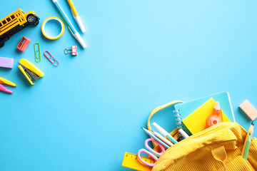 Back to school concept with school supplies scattered on a vibrant blue background. The image...