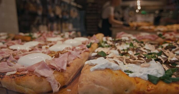 A close-up of a pizza lying on the counter in a pizzeria. Comfort food cheese and sausage pizza street food. High quality 4k footage