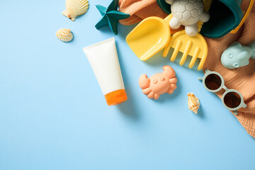 Summer Vacation Concept with Beach Accessories. Flat lay composition with sunglasses, sunscreen lotion, colorful beach toys, and seashells on blue background.
