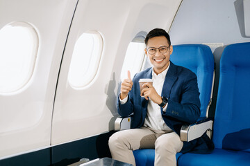 Asian executive excels in first class, multitasking with digital tablet, laptop and smartphone....