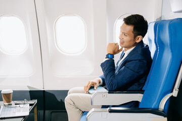 Young Asian executive excels in first class, multitasking with digital tablet, laptop and smartphone.