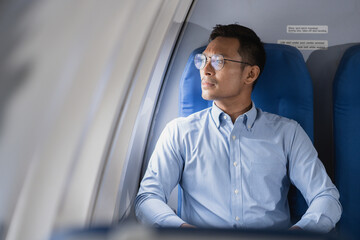 Tired asian man with headache feeling sick while sitting in the airplane , Passengers near the...