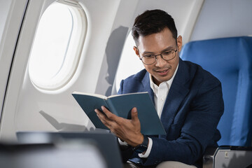 Airplane, travel and portrait of businessman working on laptop computer and smartphone while...