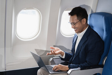 Airplane, travel and portrait of businessman working on laptop computer and smartphone while...