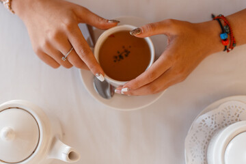Girl drinks tea, hands and a cup of tea, close-up