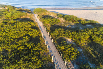 drone aerial view of a wooden walkway on a beach in summer