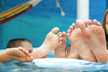 children's feet in the pool summer