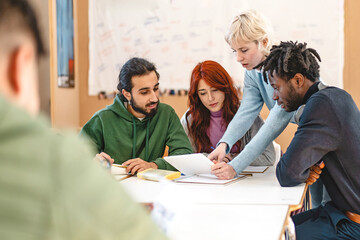 Group of diverse college students working together on a project in a classroom setting - Teamwork, diversity, and collaboration, with students engaged in discussion and study activities.