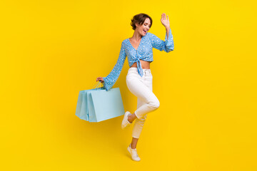 Full length photo of optimistic overjoyed pretty girl dressed print blouse dancing hold new outfit...