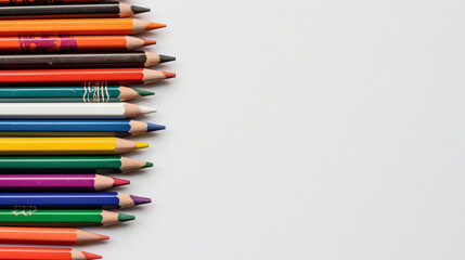 A variety of colored pencils placed randomly but aesthetically on a white background, providing ample space for text