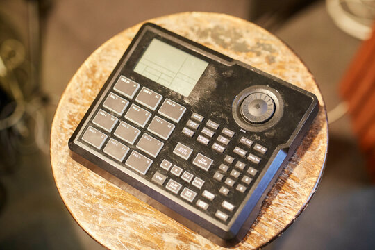 An old-fashioned calculator with large buttons and a small screen, displayed on a wooden table.