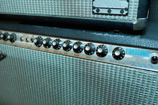 A close-up view of a vintage Vibrosonic guitar amplifier showcasing its control knobs and textured grille.