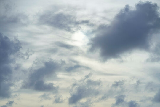 This is a serene image of a cloudy sky with sunlight trying to peek through the layers of clouds.