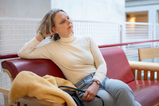 A  is sitting on a red bench indoors
