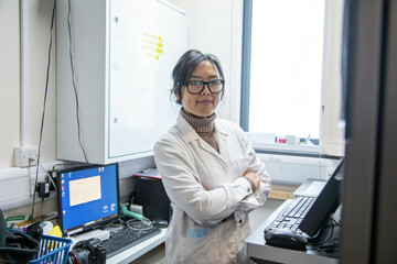 Scientist standing in a lab of a medical practice with computer equipment, UK