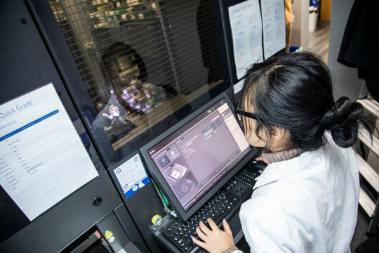 Woman working on a  modern medical device with monitor and keyboard