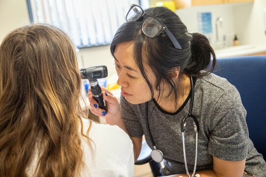 Doctor performing an ear examination on a patient