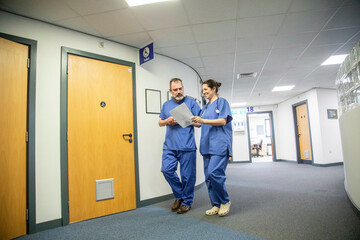 Two medical professionals walking through a hospital corridor, medical practice UK