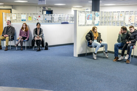 People waiting in a seating area of a medical practice in the UK