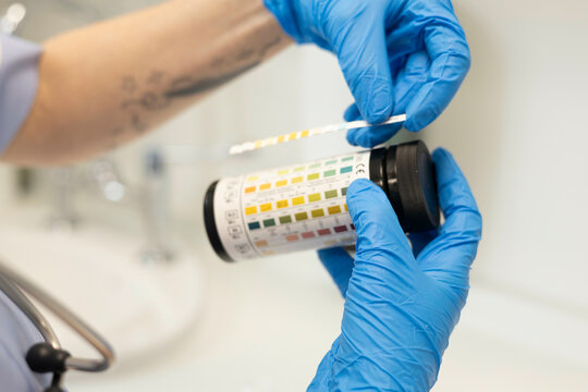 Hands in gloves handling a test result 