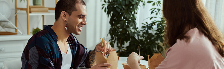 A gay couple in casual clothes sit at a table, engrossed in conversation and sharing quality time...