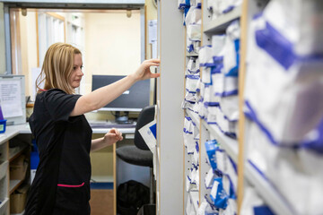 Nurse retrieving a file from a hospital storage system