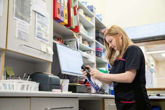 Veterinary technician scanning item at clinic workstation